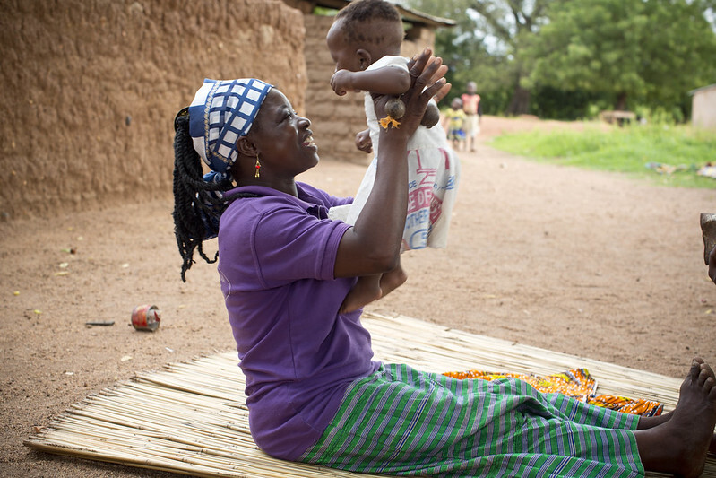 African mother holding up a baby.