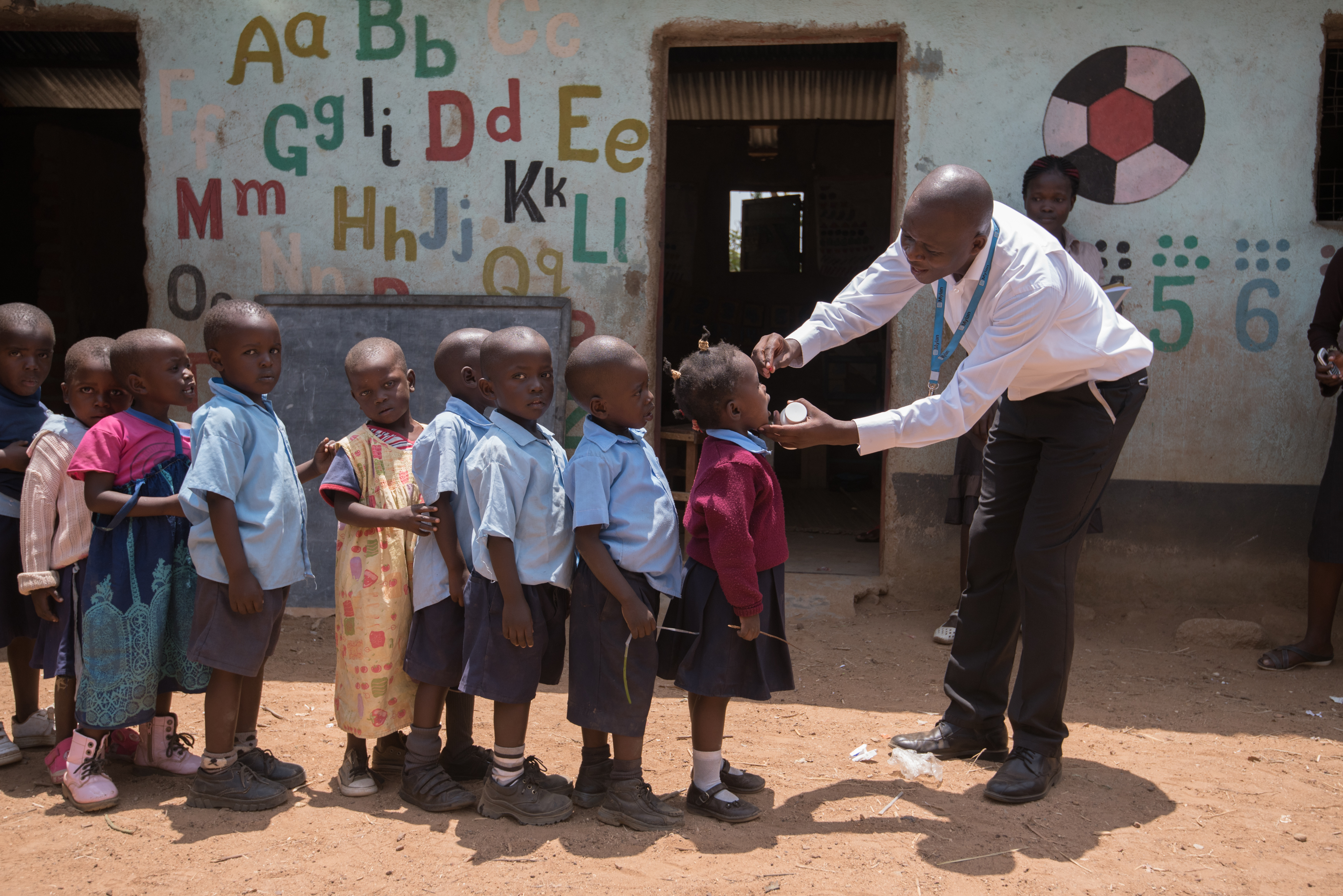 Kenyan children lined up for their temperature to be taken.