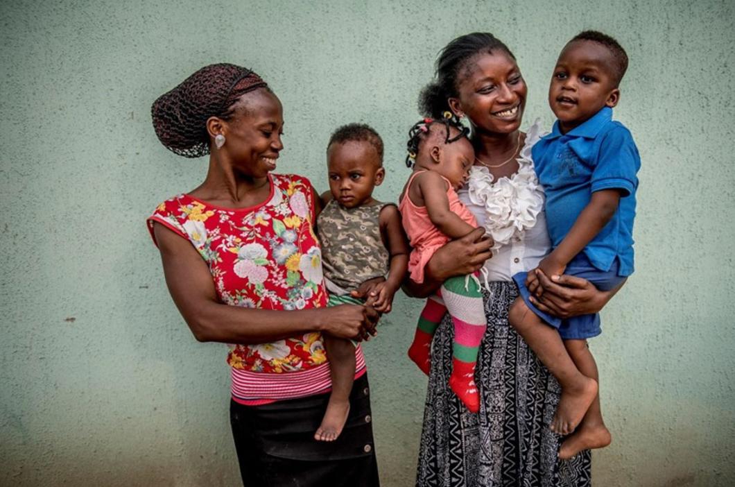 Photo of two women holding three young children