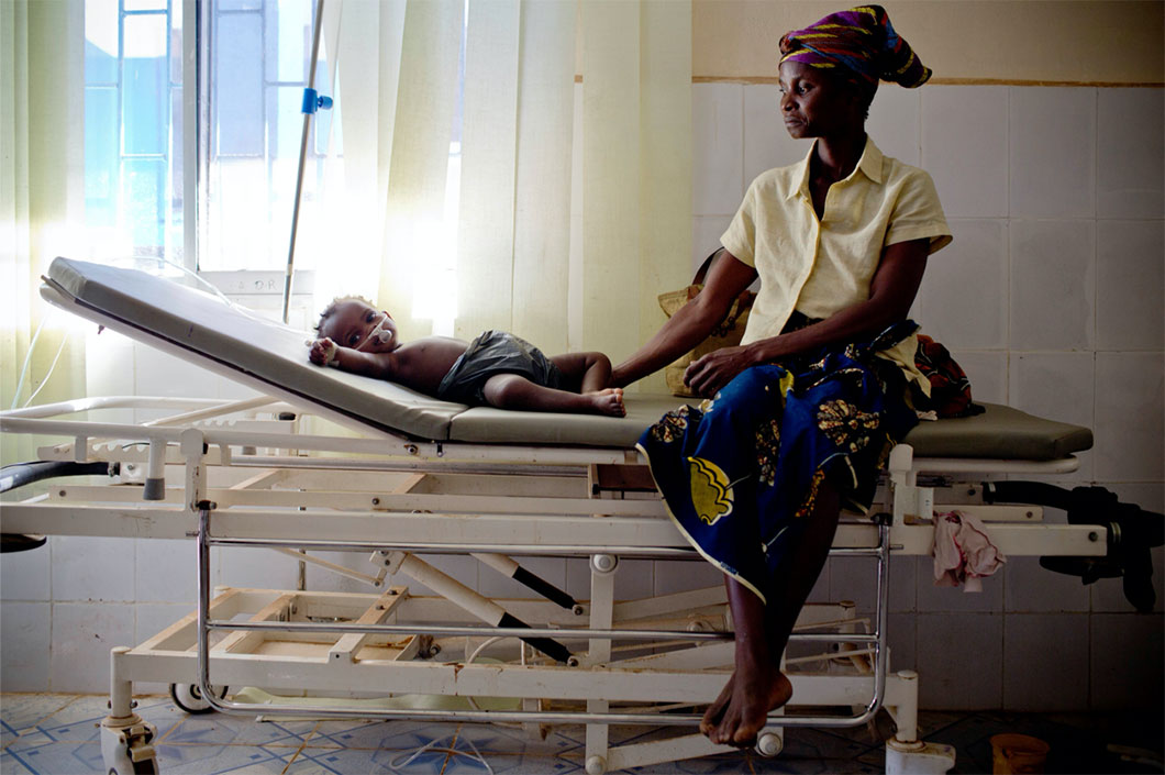 Photo of a woman with a baby on a hospital bed.