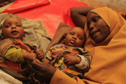 Première page de l'étude de cas du Nigeria. Femme allongée avec deux jeunes enfants.