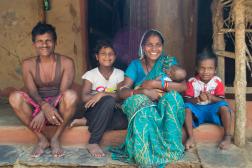 Family from Uttampur, Odisha, India sits on the step of their house.