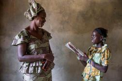 A mother in Senegal joyfully listens to her child read