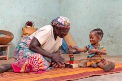 Femme jouant avec des blocs sur un tapis avec enfant