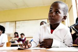 African boy sitting at his desk at school.